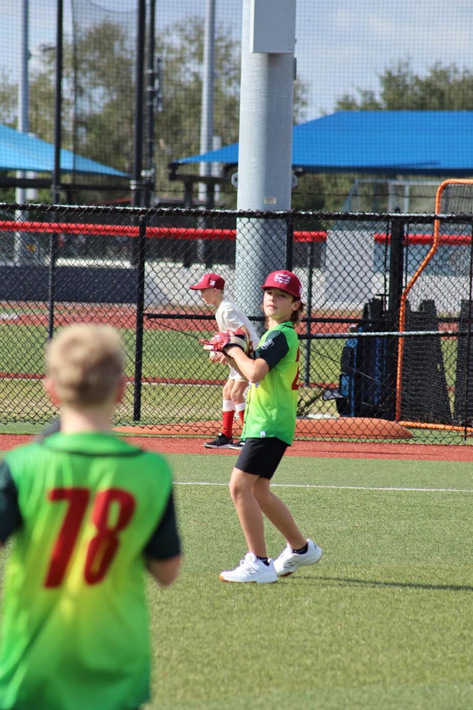 Elf Games outfielders in green jerseys tracking a play.